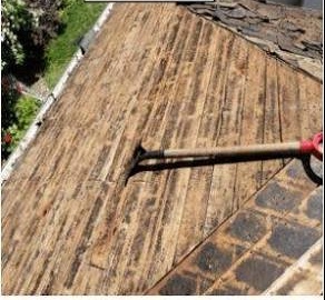 Stripped roof deck with bare, weathered boards during a Calthorpe tear-off